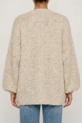 Saco abierto de punto en color beige jaspeado, con diseño de hombros caídos y mangas largas abullonadas con puños ajustados.