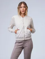 Campera bomber color beige, marca Elie Tahari. El frente es capitoneado con diseño de rombos, la espalda y las mangas son tejidas.