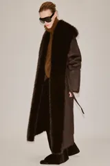 Abrigo largo de Zara Woman Collection en color marrón chocolate, con cuello de solapa amplio, mangas largas y cinturón ajustable del mismo tejido. Presenta detalles de forro interior y acabados en efecto pelo a tono en cuello, puños y bordes frontales.