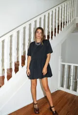 Vestido corto color verde oliva, de manga corta y corte holgado con frunce en la cintura que genera un efecto de falda globo (balloon).