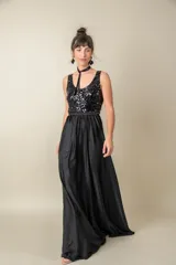 Vestido largo rojo con cuerpo de lentejuelas y falda de satén con caída fluida. Presenta escote redondo, sin mangas y un lazo en la cintura.