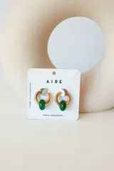 Aros dorados con dije circular de piedra natural negra.