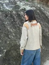 Campera color beige con apliques de cuero marrón en hombros y frente, corte recto y cierre con botones.