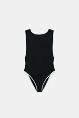 Body negro de manga sisa con escote barco y ribetes de contraste blancos en el cuello y los bordes de la pierna. Cierre inferior con botones a presión.