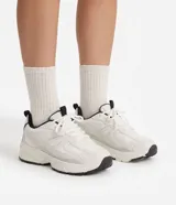 Championes de mujer Satinato estilo jogging, color blanco con detalles en negro y gris, confeccionados en poliuretano y poliéster, con suela robusta y cordones.
