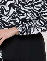 Camisa de gasa Ninety Clothing con estampado animal print en blanco y negro, cuello con solapa, escote en V, cierre frontal con botones y manga larga.