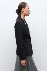 Blazer clásico de corte entallado, color negro, con cierre frontal de un botón, solapas de muesca y bolsillos laterales con solapa.