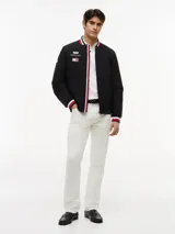 Campera estilo bomber de Tommy Hilfiger en colaboración con Cadillac Formula 1® Team, color negro. Cuenta con cuello tipo béisbol, cierre frontal de cremallera y ribetes tejidos a rayas rojas, blancas y azules en el cuello, puños y dobladillo. Presenta parches bordados del equipo en el pecho.