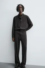 Pantalón de corte relaxed fit, con cintura ajustable, bolsillos delanteros y bolsillo trasero de plastrón. Presenta cierre frontal con cremallera y botón.