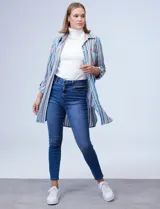 Camisola estampada a rayas verticales en tonos celeste, azul, naranja y marrón. Cuello con solapa, abertura central con botones y bolsillo aplicado en el pecho. Mangas largas regulables con presilla y botón. Laterales con bolsillos en costura. Marca Ruby Rd.