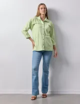 Camperita de mujer Ruby Rd. color verde lima con rayas blancas horizontales. Presenta cuello camisero, cierre frontal con botones metálicos a presión y bolsillos delanteros con solapa. Las mangas son largas y se pueden remangar.