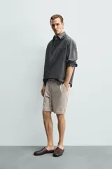 Bermuda regular fit de tejido elástico color blanco, con cintura elástica ajustable mediante cordón, bolsillos delanteros y bolsillos traseros de vivo.