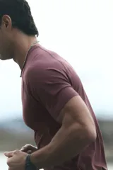 Remera deportiva de manga raglán y cuello redondo, color bordó, con diseño de tejido técnico texturizado y costuras planas, corte ajustado al cuerpo tipo muscle fit.