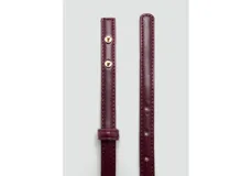 Cinturón fino de poliuretano color bordó con hebilla metálica dorada de diseño rectangular.
