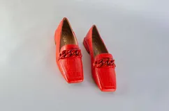 Mocasines verdes con textura símil piel de reptil y detalle de cadena plástica en el empeine.