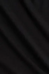 Top de manga larga de punto suave de viscosa color negro, con escote bote y diseño entallado. Presenta pliegues fruncidos en un hombro y en el lateral opuesto de la cintura para generar un efecto drapeado.