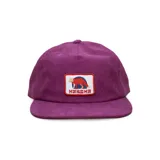 Gorra tipo snapback de corderoy color violeta, con visera plana y parche bordado frontal con diseño de zorro y logo de la marca.