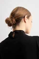 Blusa de lurex negra sin mangas, con cuello alto drapeado y detalle de pliegues frontales.