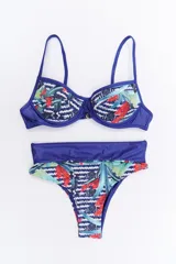 Conjunto de bikini con corpiño de aro y bombacha de tiro alto, ambos con diseño estampado de hojas tropicales y patrones geométricos en tonos azules, rojos y verdes, con detalles en tela azul lisa.