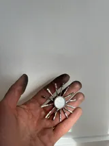 Collar con dije en forma de sol hecho a mano con centro de nácar redondo y rayos de plata. Incluye tiento de gamuza largo para usar doble o largo.