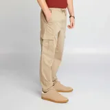 Pantalón de jogging color beige con bolsillos cargo con solapa.