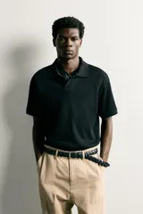 Polo regular fit color blanco, de manga corta con cuello solapa, abertura frontal y acabado en rib con textura de rayas verticales.