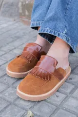 Mules de cuero color marrón con detalle de flecos en la capellada y suela de goma.