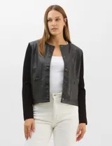 Chaqueta Sioni con frente de cuero sintético y mangas y espalda de tejido de punto. Presenta cuello a la base, cierre frontal con botones a presión y bolsillos delanteros.
