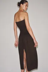 Vestido midi de corte bandeau con escote palabra de honor y detalle de vuelta en el pecho. Presenta una cintura entallada con pliegues y una falda con volumen en tejido combinado a tono.