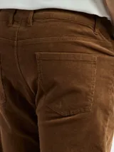 Pantalón de pana de corte recto, con bolsillos traseros y cierre de botón y cremallera.