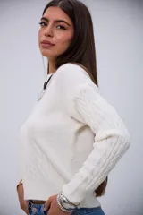 Sweater de punto color crudo con cuello redondo, diseño de ochos y mangas largas.