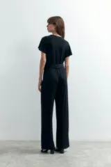 Mono largo de lurex negro con escote cruzado, mangas cortas y corte palazzo.