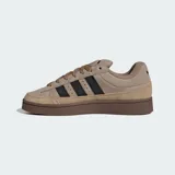 Championes Adidas Campus ST de estilo urbano inspirado en los años 90. Presentan un exterior de gamuza y lona en tonos marrones con las icónicas tres tiras laterales en color negro. Cuentan con suela de caucho resistente y cierre mediante cordones.