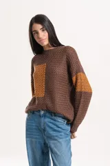Buzo de tejido de punto con diseño combinado en tonos marrón y ocre, de cuello redondo y manga larga.