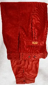 Bombacha de campo de pana color rojo, con trabillas para cinturón y botones de madera en la cintura y los tobillos.