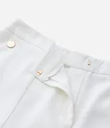 Bermuda de tiro alto confeccionada en crepé color blanco, con cierre frontal, bolsillos laterales y detalle de botones decorativos.