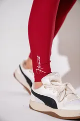 Calza deportiva de tiro alto en color bordó, confeccionada en tejido elástico con diseño sin costuras.