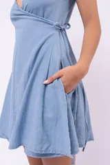 Vestido corto azul claro, estilo cruzado con escote en V y tirantes finos.