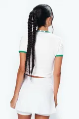 Minifalda deportiva blanca con cintura alta, calza interna y bolsillo lateral para pelota.