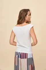 Top blanco con textura, escote asimétrico y un hombro descubierto, de calce relajado y silueta fluida.