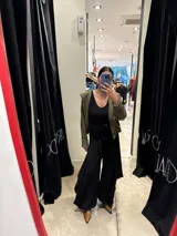 Pantalón negro de corte amplio y fluido, con cintura elástica y lazo ajustable, diseñado con una silueta holgada tipo palazzo.