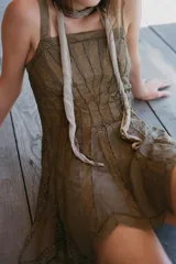 Vestido corto de escote recto y tirantes anchos, confeccionado en tejido combinado con aplicaciones de encaje a tono y detalle de godets en la falda. Cuenta con cierre lateral oculto.