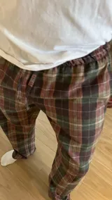 Pantalón de hombre confeccionado en franela a cuadros grises y marrones, con elástico en la cintura y dos bolsillos laterales.