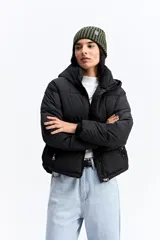 Campera puffer negra con cuello alto, cierre frontal y bolsillos laterales con cierre. Diseño acolchado de volumen medio.