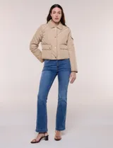 Campera corta capitoneada Michael Kors de color beige, con diseño acolchado en rombos, cuello camisero, cierre frontal de botones metálicos a presión y bolsillos frontales con solapa. Incluye un pequeño bolsillo en la manga.