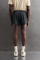 Short de baño rojo de tejido técnico ligero y elástico, con cintura elástica ajustable mediante cordón blanco y aberturas laterales en las perneras.