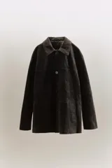 Cazadora oversize de piel de ante 100%, con cuello solapa, manga larga, bolsillos laterales de vivo y bolsillo de plastrón en el pecho. Cuenta con forro interior a tono y cierre frontal con botones.