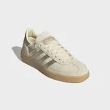 Championes Adidas Handball Spezial de gamuza en color beige, con las clásicas tres tiras metalizadas en tono dorado, talón a juego, inscripción "SPEZIAL" lateral y suela de goma translúcida.