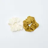 Pack de dos coleteros tipo scrunchie de tela satinada, uno en color blanco y otro en color verde oliva.