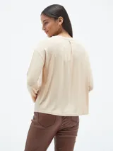Blusa de manga larga color azul, con cuello redondo y estampa frontal geométrica con detalles de lentejuelas y texto.